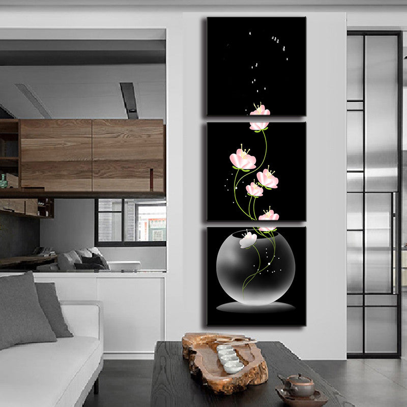 Fishbowl and Flowers wall art featuring delicate pink blooms floating from a transparent glass sphere against a dramatic black background, displayed as a vertical three-panel canvas print perfect for modern home decor