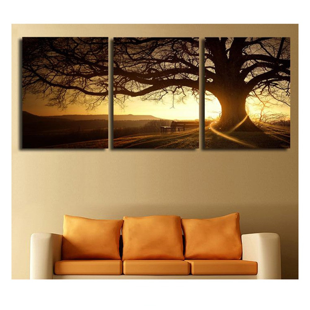 Tree in the Sunset - 3-panel canvas wall art featuring a majestic tree silhouette against a golden sunset sky, with distant mountains and a bench, creating a serene landscape perfect for home decor